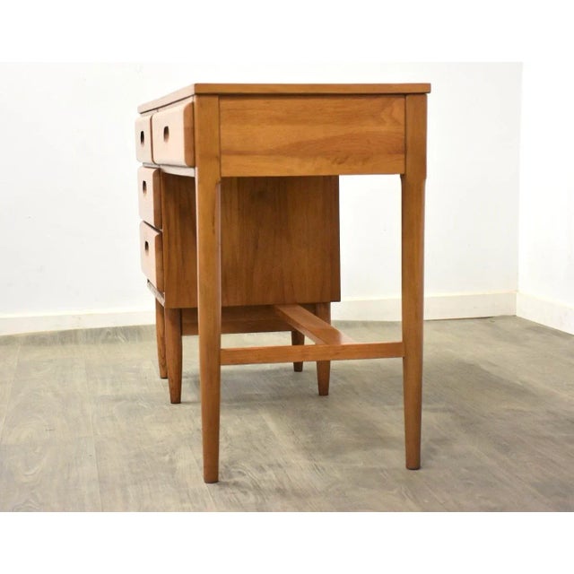 A mid century modern oak desk in a teak color finish with inset pulls and a finished back. 50” wide. 18.75” deep. 30” tall.