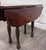 This is an antique 19th-century walnut Pembroke drop-leaf table featuring a richly figured solid wood top, shaped leaves,...