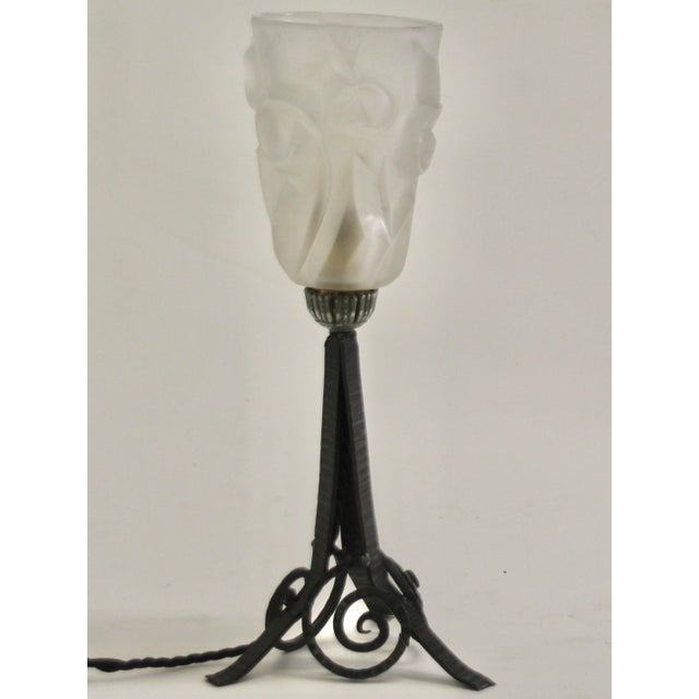 1920s Art Deco table light with geometric motifs in the glass as well as in the wrought iron base. Designed and produced...