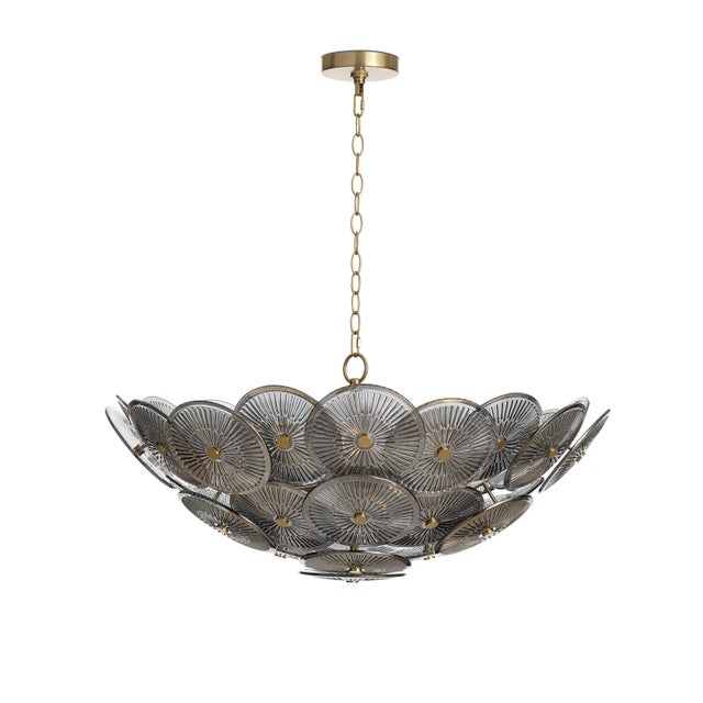 The Holly chandelier is captivating, featuring overlapping glass discs with intricate linear details reminiscent of...