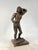 A beautiful, handcrafted bronze sculpture depicting a man with a shell and a staff. The work rests on a wooden base, ideal...