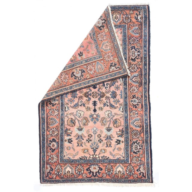 A soft rose border of petal and ragged palmettes in dark and light blue frames the buff field with a centralized pattern...