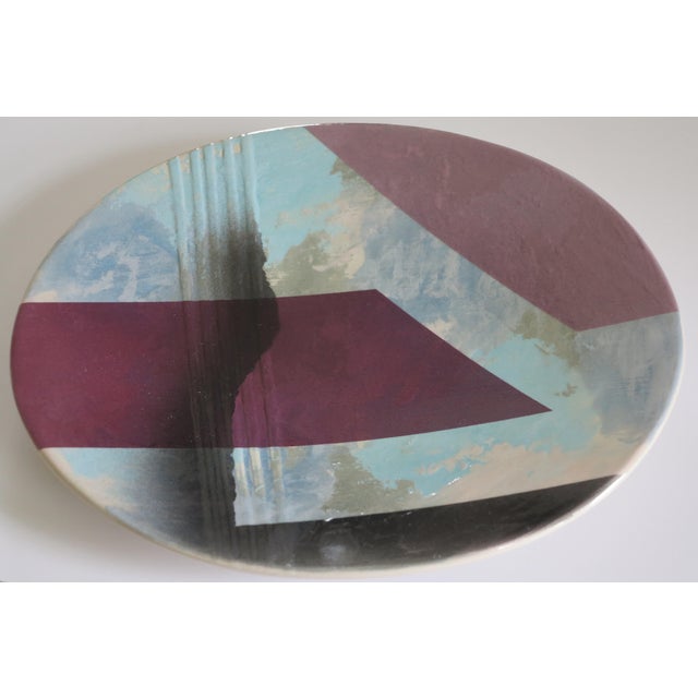 A very cool 1980s hand painted platter with a bold geometric motif over what appears to be clouds or ice-like background....