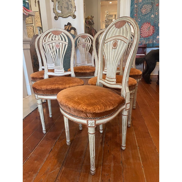 A set of six painted, French Louis XVI style dining chairs with stylized "balloon" or Montgolfier backs. In keeping with...