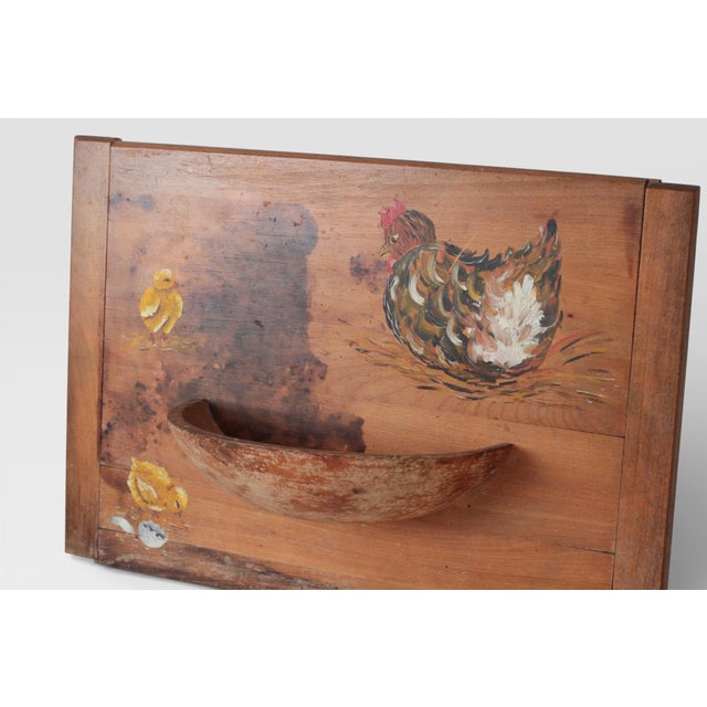 Vintage wooden wall pocket featuring hand-painted folk art imagery of a hen and chicks. Constructed from solid wood with a...