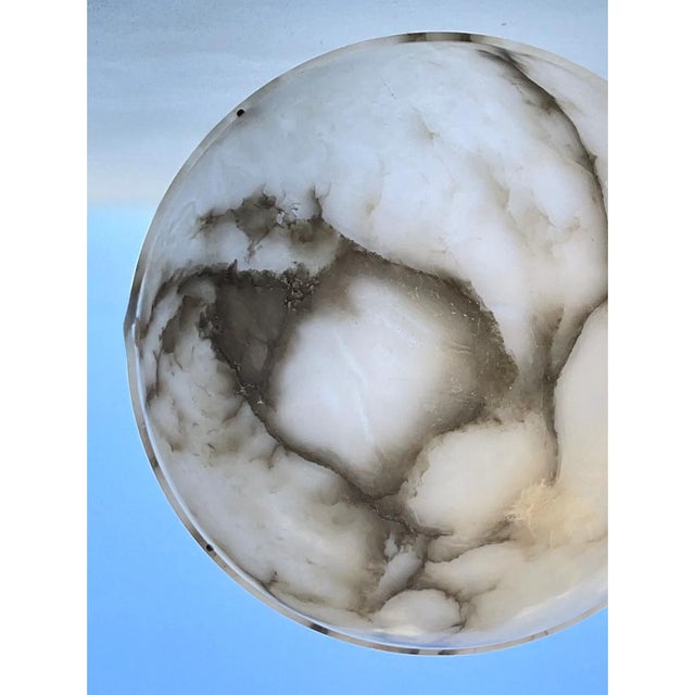 Crafted from solid carved alabaster and wrought iron, this mid-20th-century bowl pendant light masterfully pairs organic...