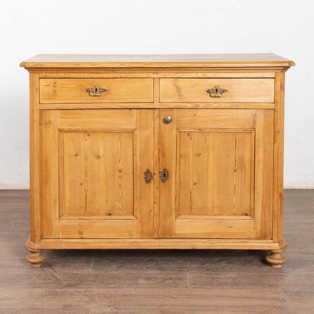 Danish pine sideboard with clean lines; two drawers over two doors, one interior shelf. Restored and waxed, this cabinet...