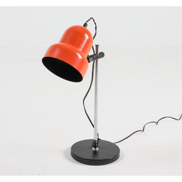 A bright orange and black Mid-Century adjustable table lamp in the style of Swedish brand Fagerhult. The lamp offers...