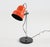 A bright orange and black Mid-Century adjustable table lamp in the style of Swedish brand Fagerhult. The lamp offers...
