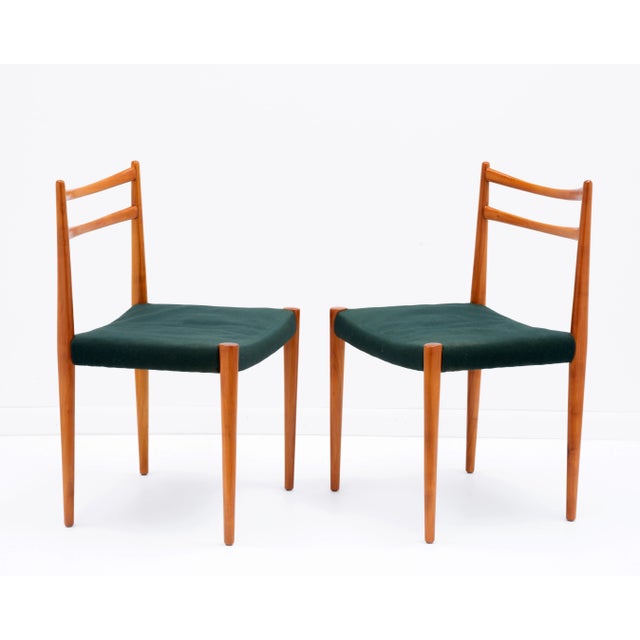 A pair of Mid Century dining chairs by Lübke of Germany. Cherry wood with the original dark green fabric.