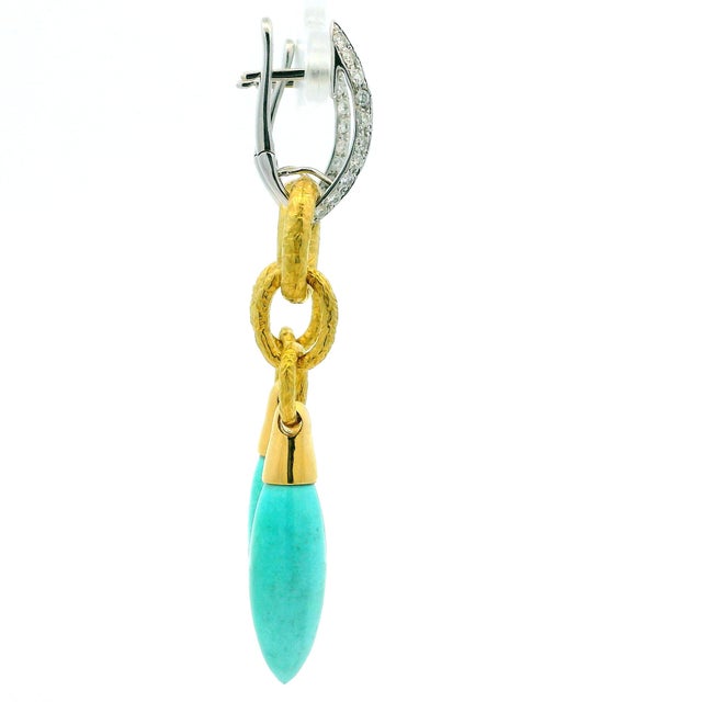 A beautifully crafted pair of Italian 18K gold drop earrings featuring articulated hammered yellow gold links suspended...
