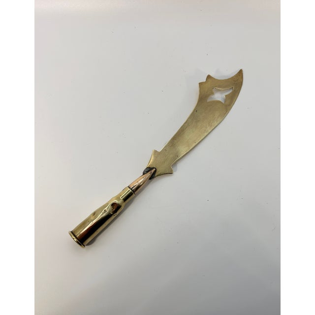 A collectible example of World War I trench art, this letter opener was crafted from a shell casing and brass, and etched...