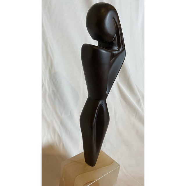 Mid-century modern hand-carved sculpture figure of a woman on an alabaster base.