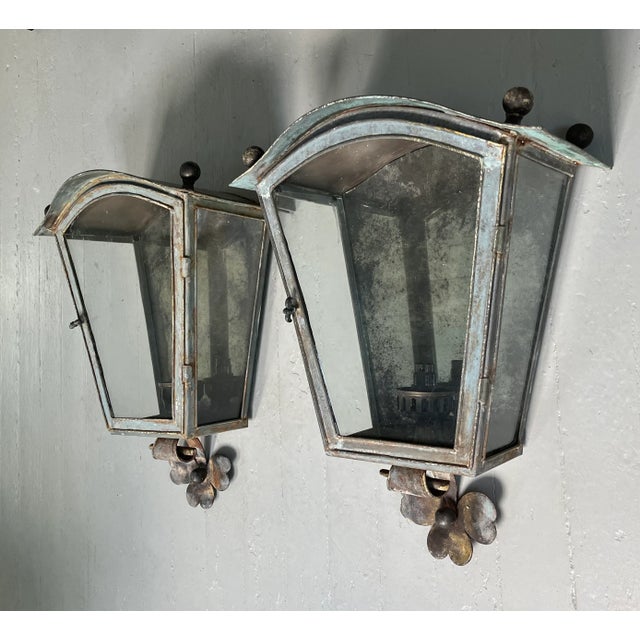 Pair French patinated copper and tole wall lanterns with ball finials. Each with a front door that opens to reveal a...