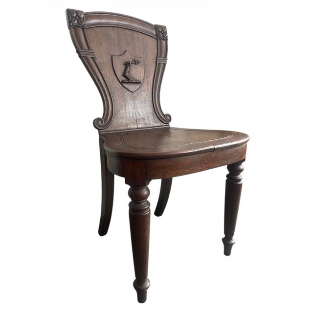 This distinguished 19th-century English hall chair is a classic example of Victorian-era Neoclassical revival furniture....