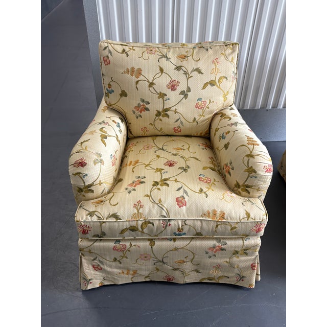 Pair of upholstered rolled arm chairs in a Scalamadre fabric called Millefiori. A floral pattern with a creme/ beige base....