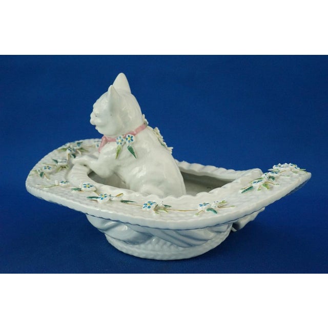 Beautiful hard-paste porcelain pocket emptier, entirely hand-decorated and glazed, featuring a sculpture of a kitten...