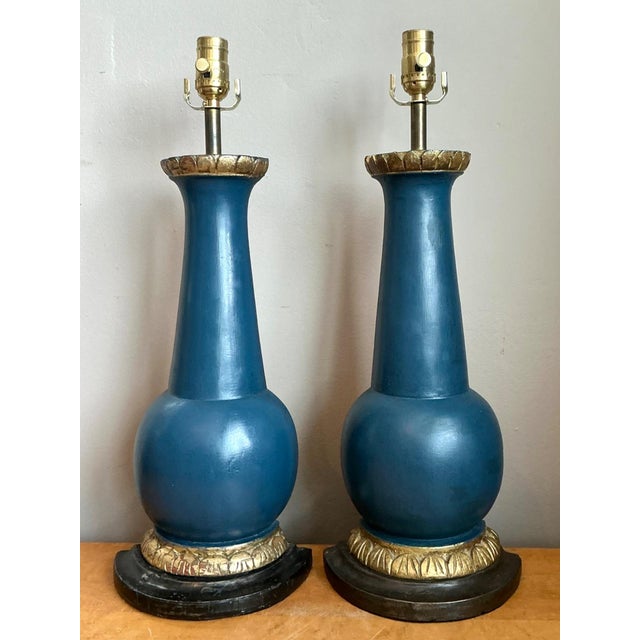 This pair of vintage table lamps is crafted from wood with brass fittings, in a design consistent with mid-20th-century...