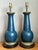 This pair of vintage table lamps is crafted from wood with brass fittings, in a design consistent with mid-20th-century...