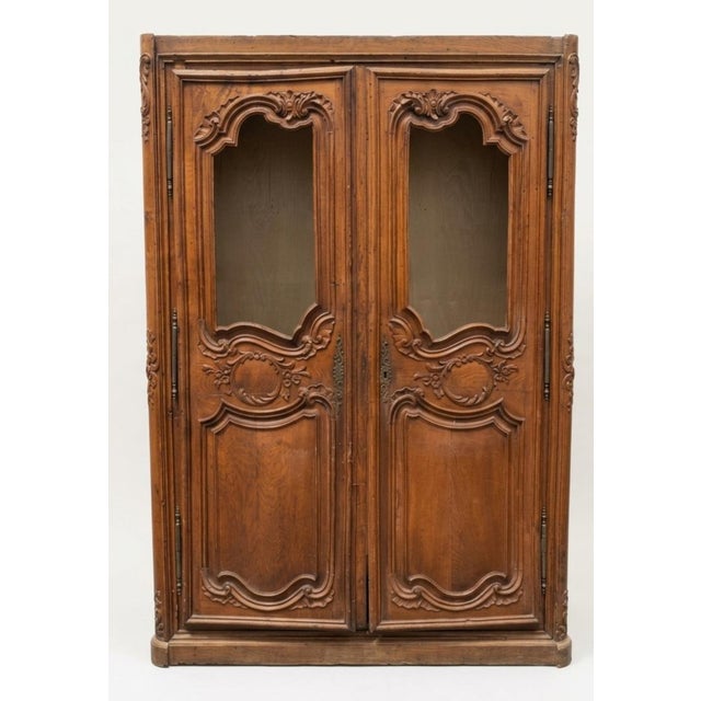 This piece is a classic French Provincial Louis XV style double-door armoire or display cabinet, showcasing characteristic...