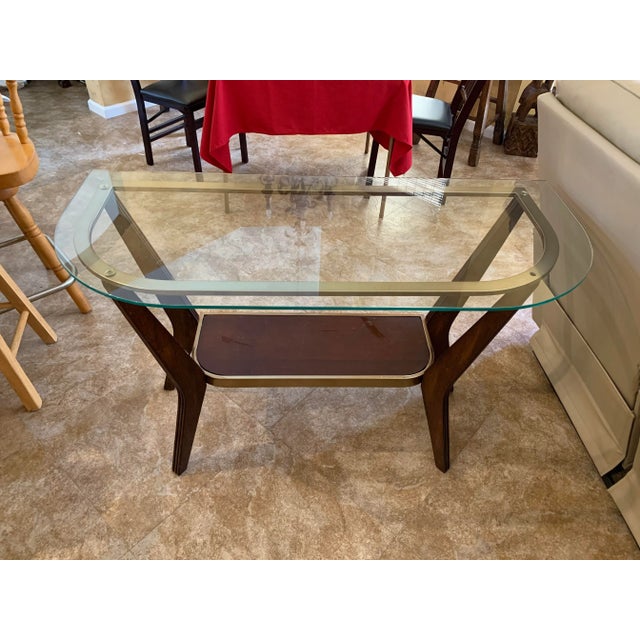 Mid Century side glass top table. The glass top measures 20” x 46” and is the shape of a half square with rounded edges....