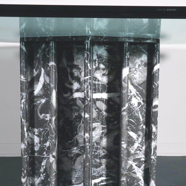 A stunning sculptural black marble table base with graffiti like effect and a beveled octagonal glass top. A true work of...