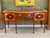 This early 19th C. English Hepplewhite sideboard has a serpentine mahogany top with a wide satinwood crossbanded border...