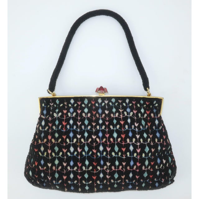 This delicate and ultra feminine C.1950 French black seed bead handbag features a floral chain stitch pattern in pastel...