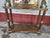 Ornate hall tree is constructed from brass- with a large rectangular central mirror. This piece has four double-pronged...