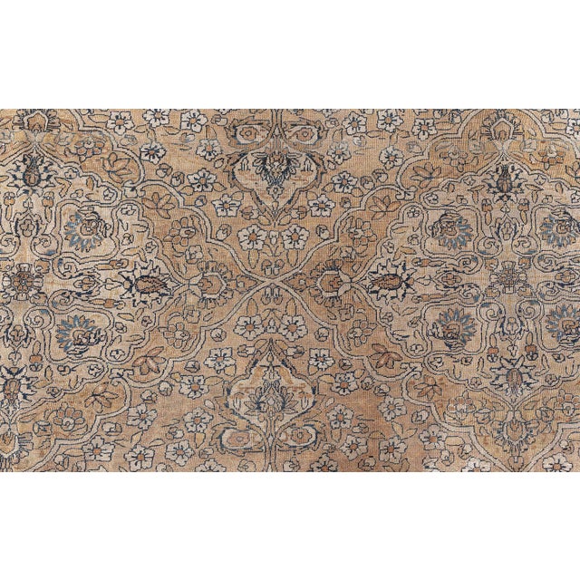 A late 19th century Persian Kerman carpet, the camel field with scattered floral motifs and palmettes overall around...