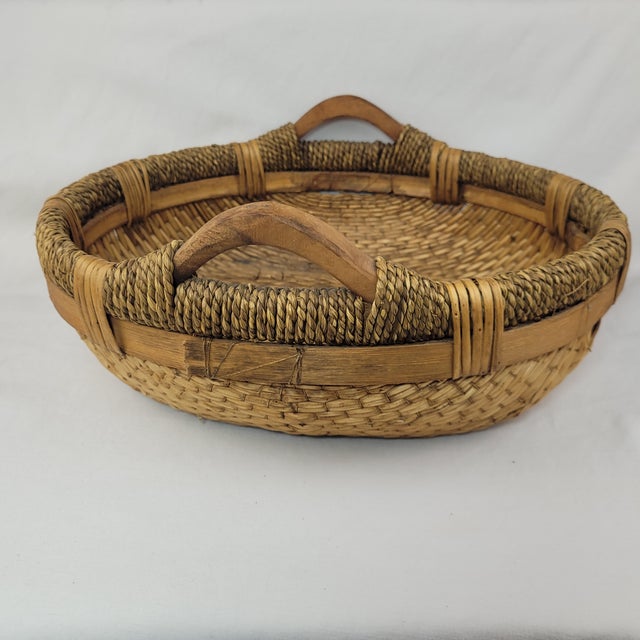 Handcrafted round wicker basket features a sturdy woven design with integrated wooden handles, perfect for rustic home...