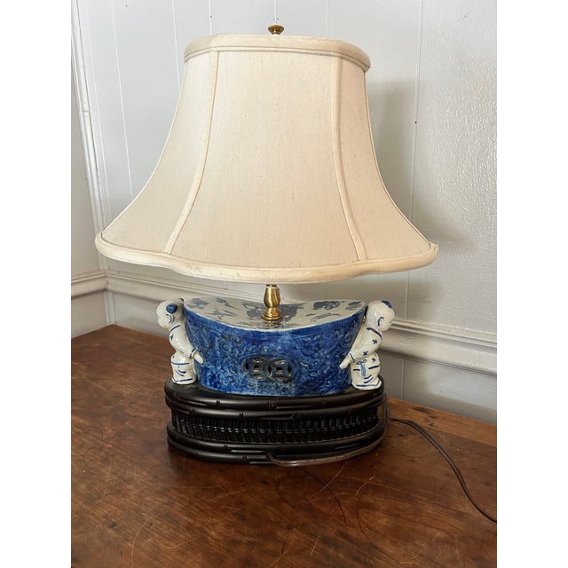 A Vintage Blue & White Table Lamp decorated with hand-painted motifs. Ceramic/porcelain body with a dark wooden stand....