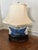 A Vintage Blue & White Table Lamp decorated with hand-painted motifs. Ceramic/porcelain body with a dark wooden stand....