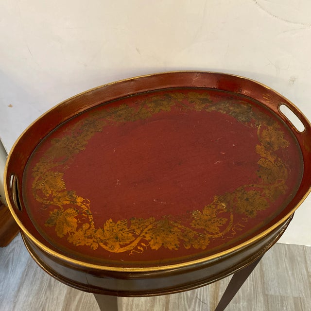 An Antique hand painted 19th Century Italian tole tray with custom mahogany base. The oval tray is 19 inches by 15 inches...