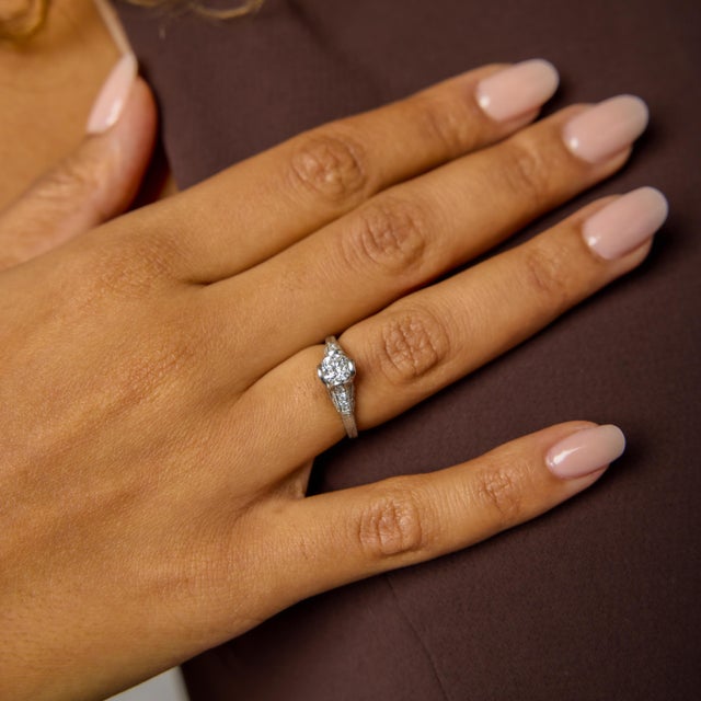 This Art Deco engagement ring is a graceful expression of early 20th-century elegance, defined by balance, symmetry, and...