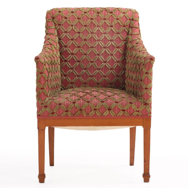 A stylish pair of Italian maple armchairs, circa 1940, featuring a classic barrel-back silhouette with straight crest...