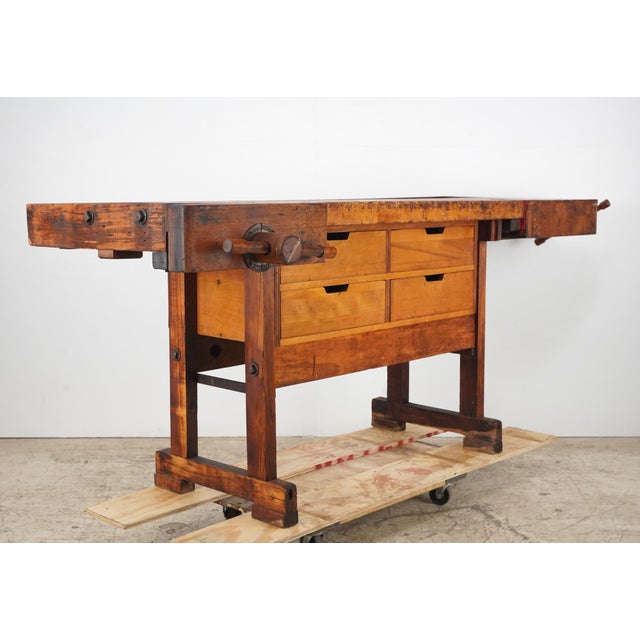 Vintage industrial maple woodworkers workbench with two functional vises, a parts tray, and four storage drawers. The...