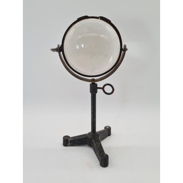 A unique, historic optical instrument in the form of a large converging lens, set in a brass frame and mounted on a heavy...