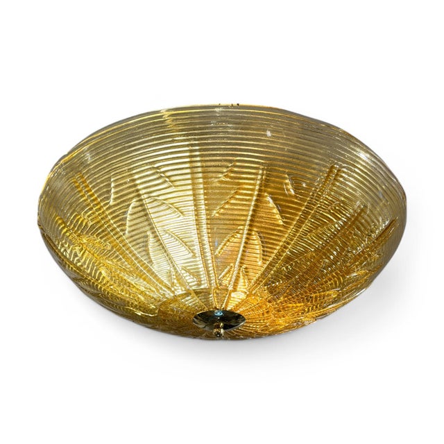 This circular ceiling light, crafted from Murano glass in a beautiful caramel amber hue and accented with brass details,...