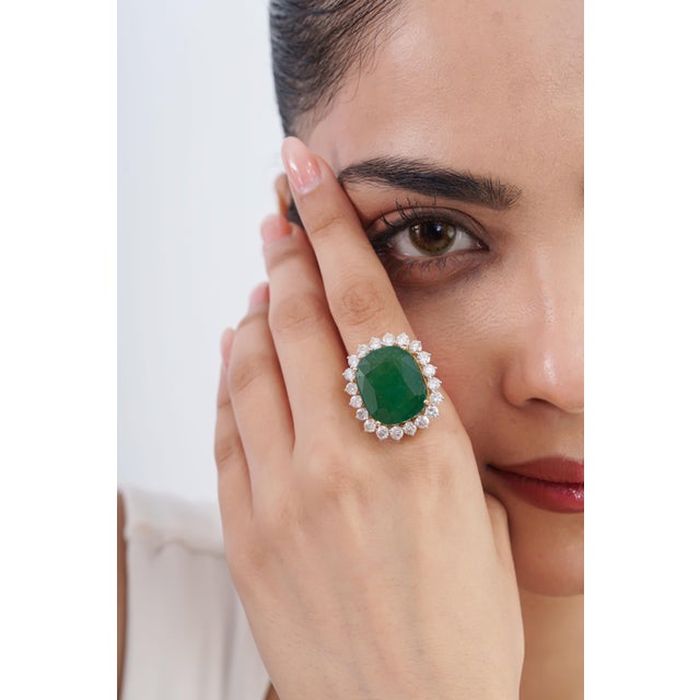 This Art Deco-style cocktail ring features an 18.05-carat cushion-cut natural emerald, set in 14K yellow gold. The big...
