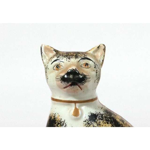 Pair of Staffordshire Pottery Seated Calico Cats Circa 1850–1870 Each cat is modeled seated on its haunches with its tail...