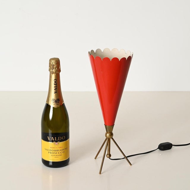 Marvelous mid-century tripod table lamp in red enameled metal and solid brass. This incredibly elegant and unique piece...