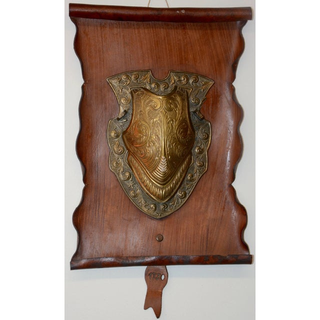 We are offering a vintage reproduction of a bronze shield mounted on a rustic leather scroll. The leather has rolled edges...