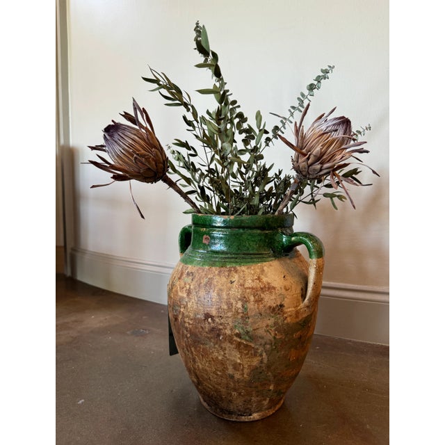 Handcrafted French olive jar with medium olive green glaze inside and on top. Exposed clay has acquired a soft patina.
