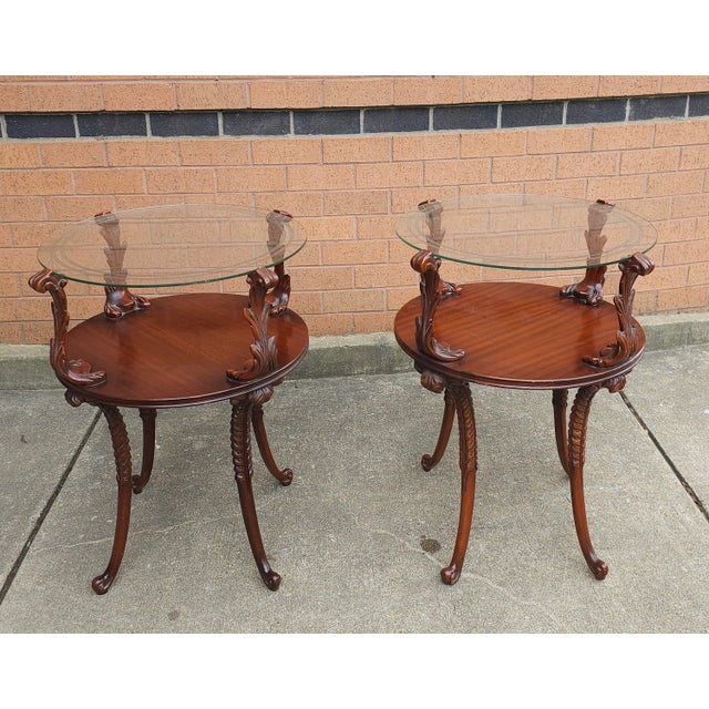 Pair of Victorian Style Two Tier Carved Mahogany with acanthus leaves and Glass Top Side Tables. Measures 20" in diameter...