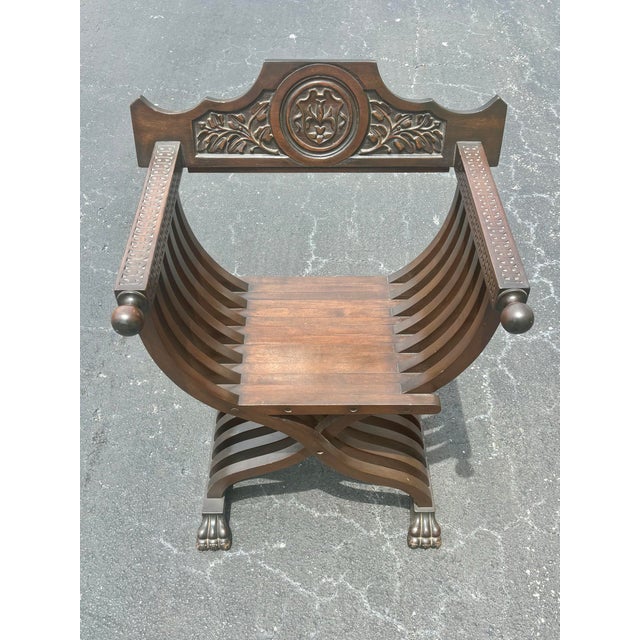 A striking Renaissance Revival Savonarola style chair crafted in carved walnut with a rich dark finish. The sculptural...