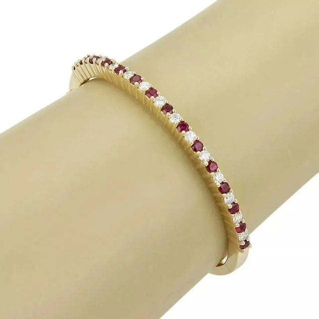 This beautiful rubies and diamond bangle bracelet is crafted from solid 14k yellow gold with a fine polished finish. The...