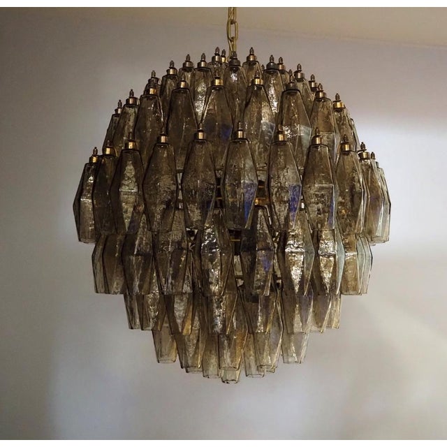 Elegant Italian pendant light made from 140 smoked Murano glasses "poliedri". Structure in gold and brass colored metal....