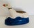 A vintage Staffordshire figural inkwell shaped like a resting greyhound or whippet on a blue pillow with gold trim. The...