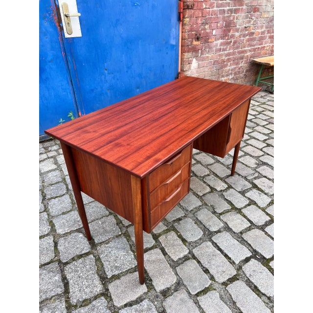 An elegant desk in a classic mid-century modern design, made of fine teak. This model dates back to the 1960s and...